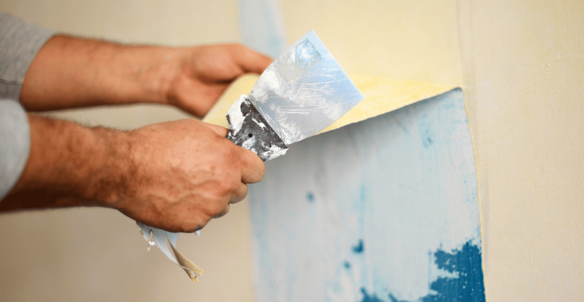 Room prepared for wallpaper removal with plastic sheeting and taped outlets